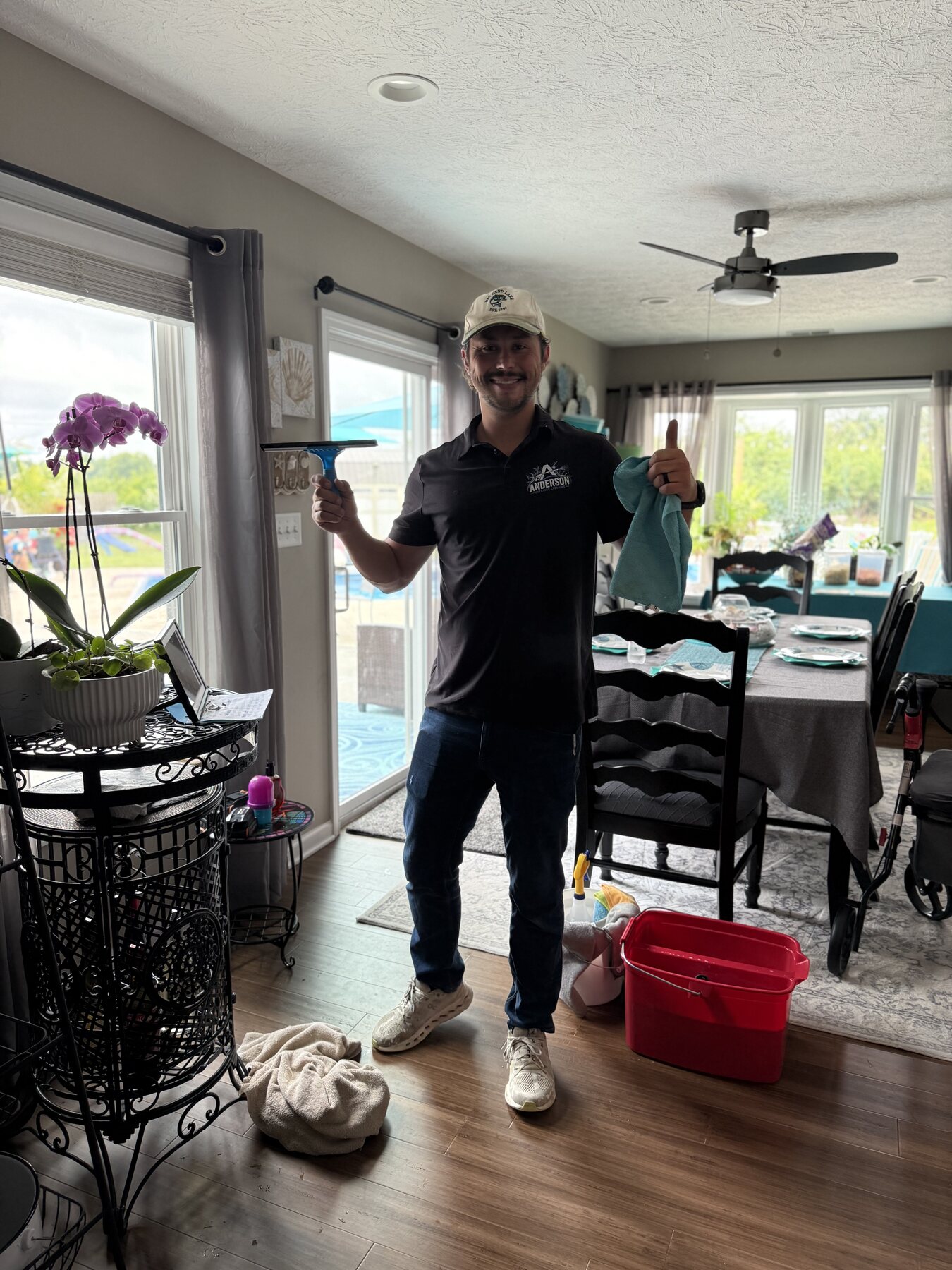 Drake Anderson holding window cleaning tools, ready to clean windows